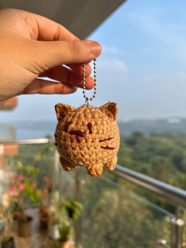 Hand holding a crochet tabby cat